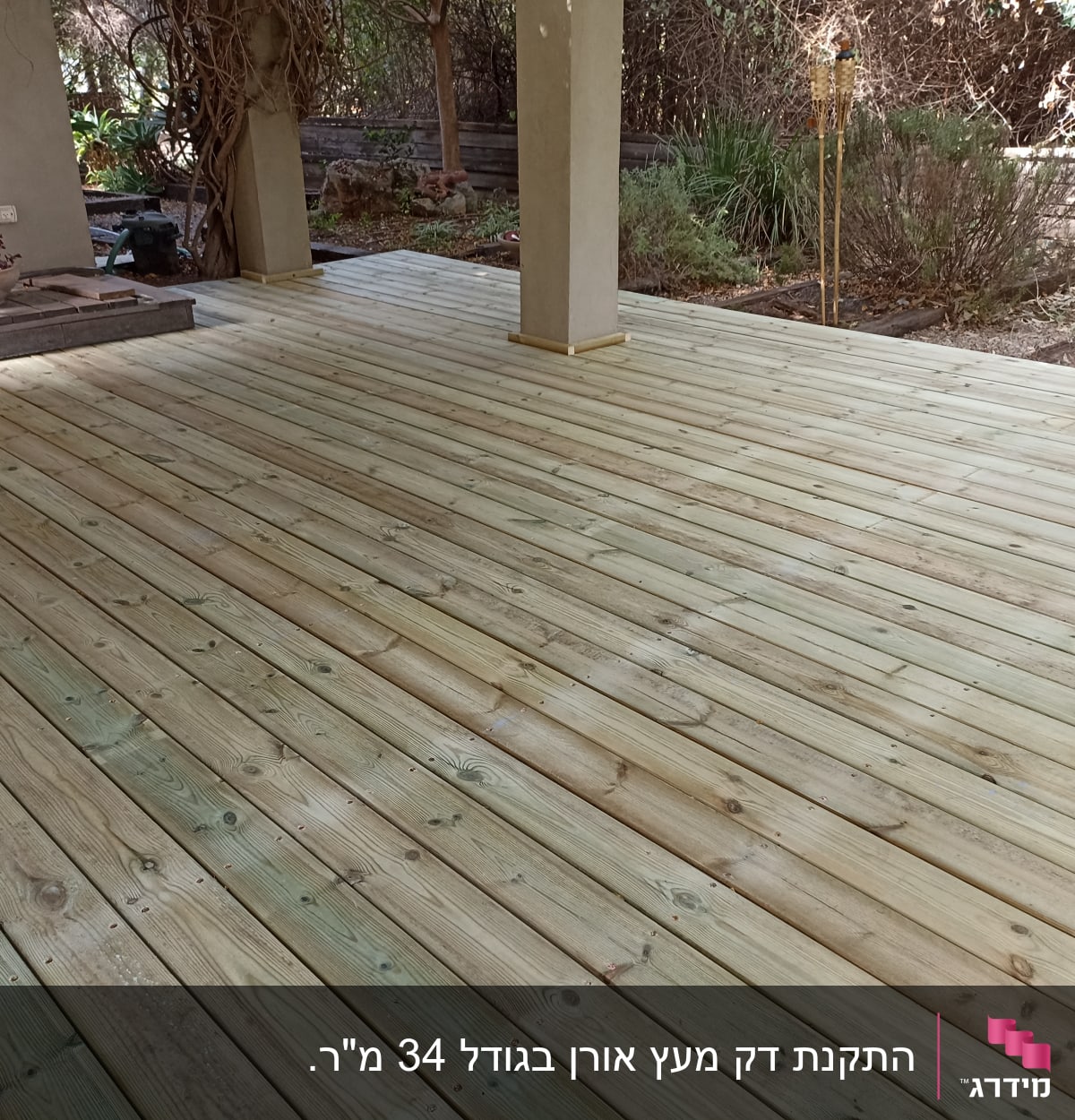 דק עץ חדש בגינה עם עמודים ותאורה